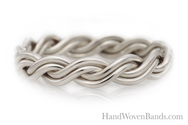 Silver four-strand chain bracelet on a reflective white surface.