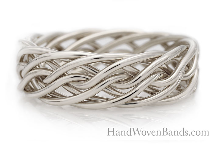 Silver handwoven eight-strand closed weave ring with intricate looping design on a reflective surface.
