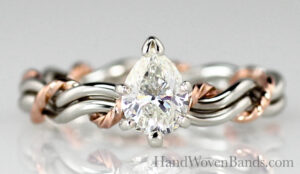 This pear shaped diamond is mounted on a braided cord of three ring. This was custom colors of 14k white gold and 14k rose gold woven and braided together in a Celtic style. Handmade by an artist. .