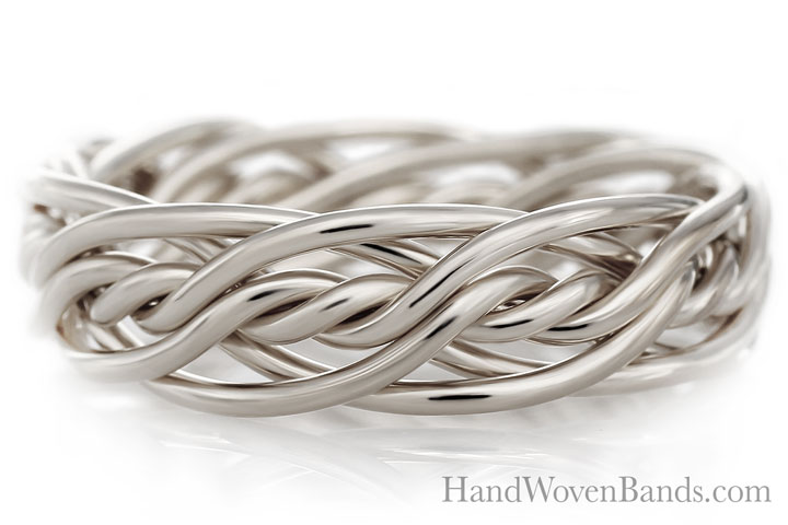Silver Seven Strand Ring with a complex, interlaced design on a reflective white surface, displaying the text "handwovenbands.com.