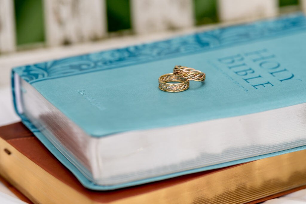 Two wedding rings from a wedding ring store placed on top of a blue holy bible.