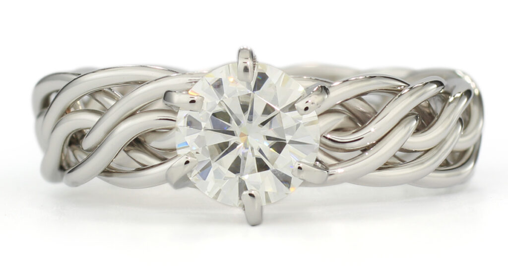 Silver strand open weave ring with a large central diamond, isolated on a white background.