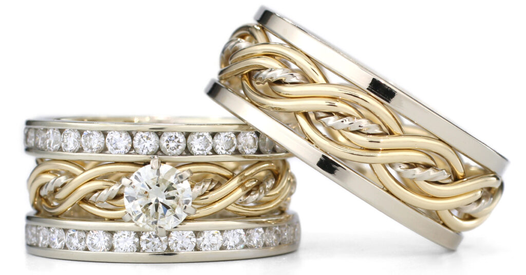 Two intertwined five-strand gold and diamond wedding ring sets on a white background, featuring a prominent solitaire diamond on one.
