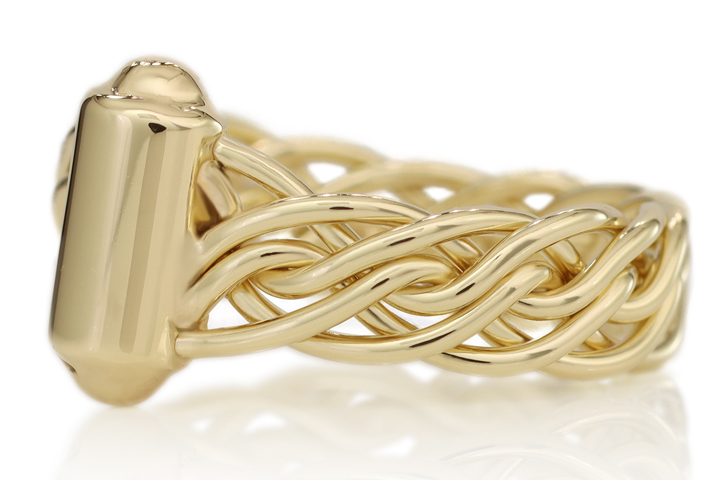Gold braided bracelet with a smooth clasp, isolated on a reflective white surface.