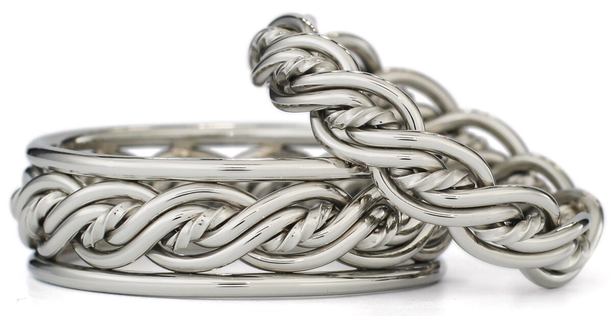 Two intertwined silver braided chain bracelets on a white background.