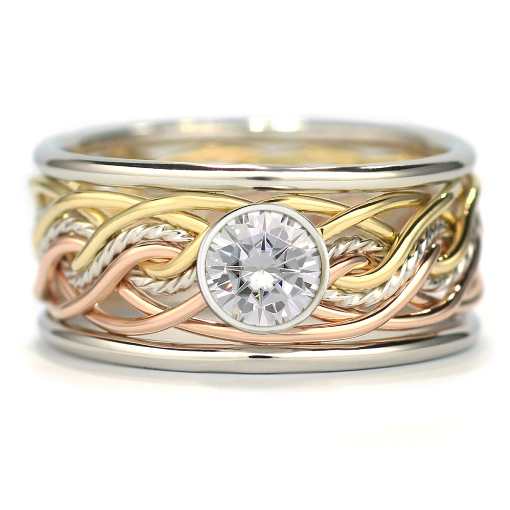 An eight-strand double weave braided band ring featuring a central round diamond, set against a white background.